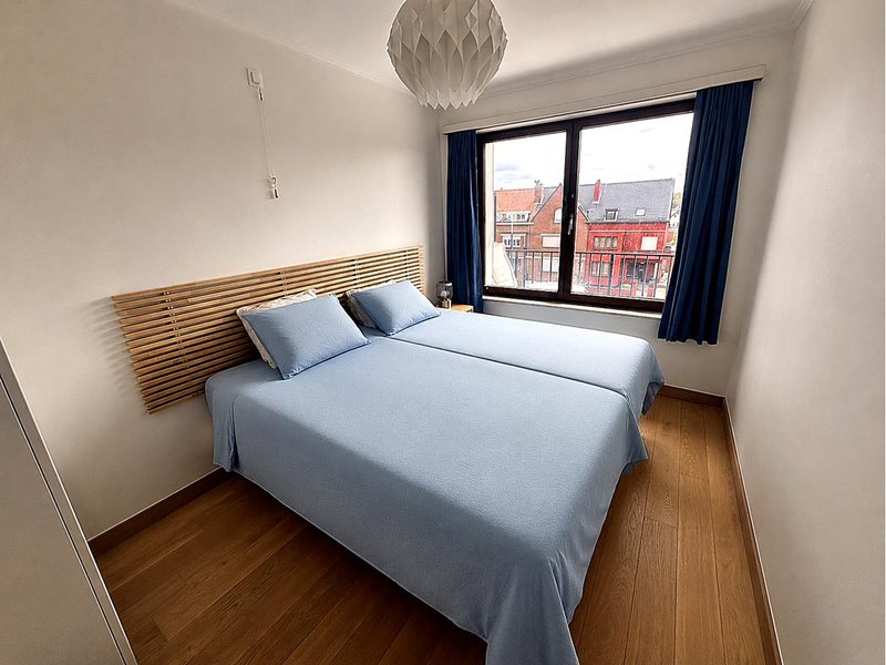 Blaues Schlafzimmer des Apartments mit Doppelbett und Blick auf Koksijde
