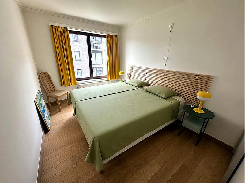 Grünes Schlafzimmer des Apartments mit Doppelbett